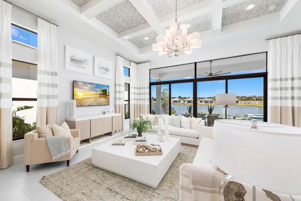 a living room with furniture chandelier and a large window