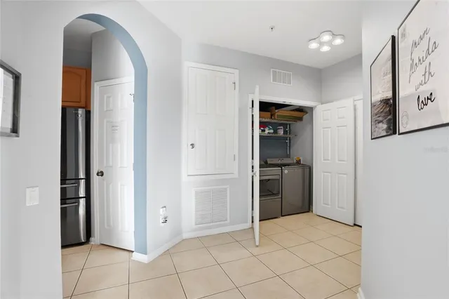 a view of a kitchen with refrigerator and window