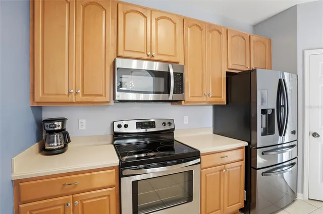 a kitchen with stainless steel appliances granite countertop a refrigerator stove and microwave