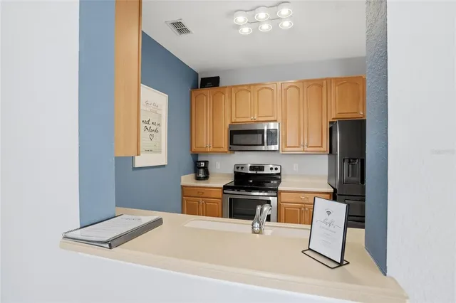 a kitchen with stainless steel appliances a stove a microwave a sink and cabinets
