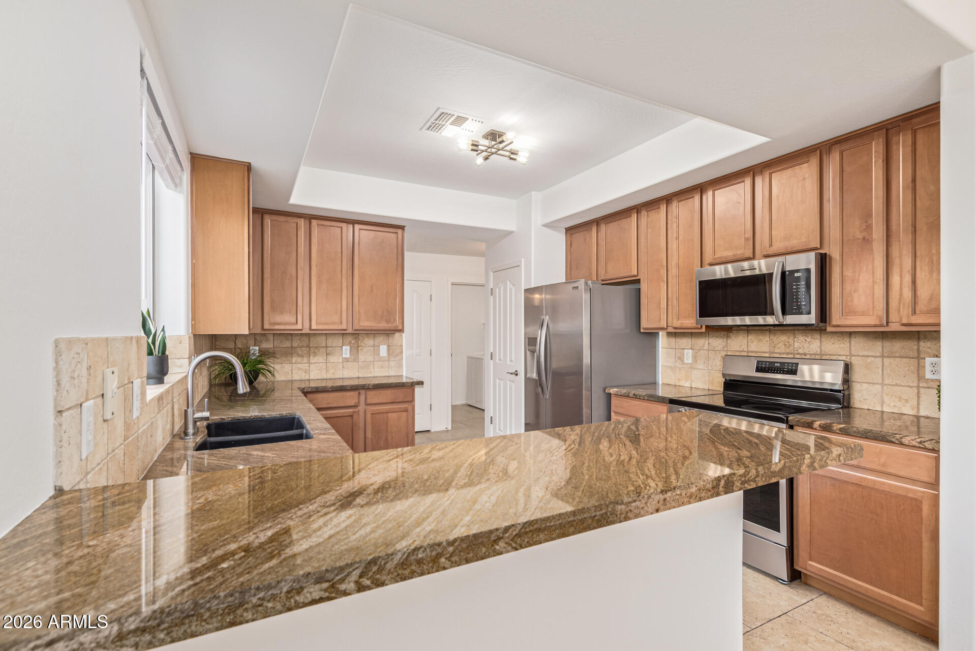 21324 Karsten Drive Maricopa, AZ 85138 - Photo 13 of 49 a kitchen with stainless steel appliances granite countertop a sink stove and refrigerator