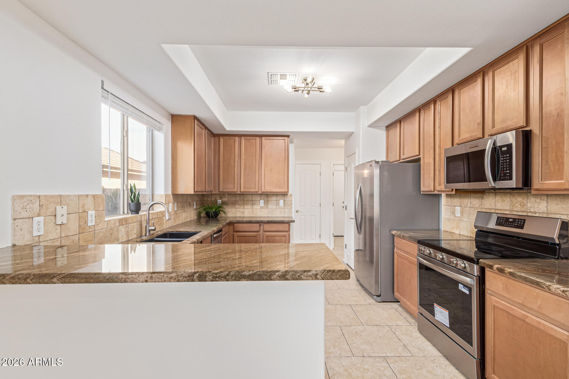 21324 Karsten Drive Maricopa, AZ 85138 - Photo 15 of 49 a kitchen with stainless steel appliances granite countertop a refrigerator a stove top oven a sink and dishwasher