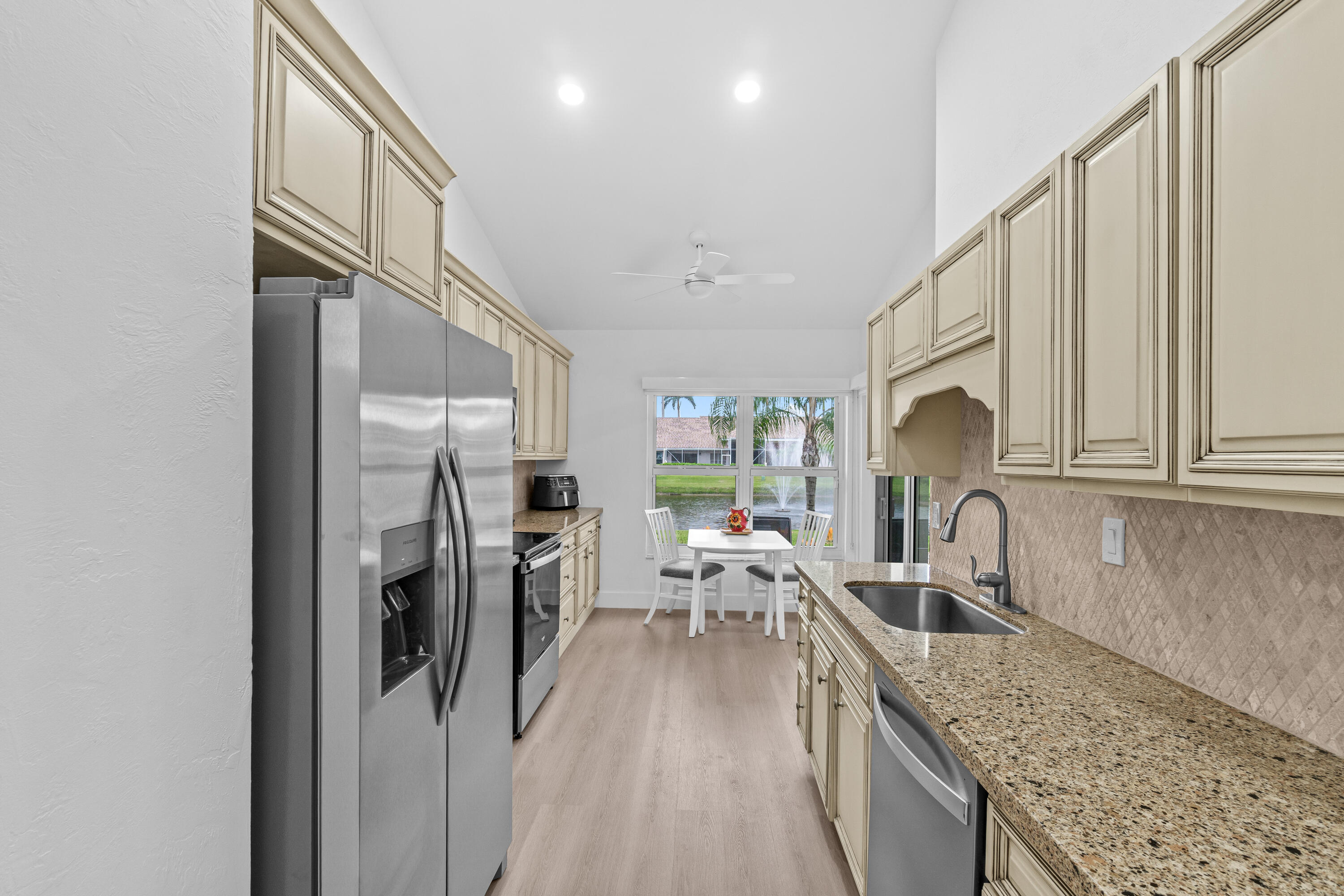 5097 Windsor Parke Drive Boca Raton, FL 33496 - Photo 13 of 30 a kitchen with stainless steel appliances granite countertop a refrigerator a stove and a sink with cabinets