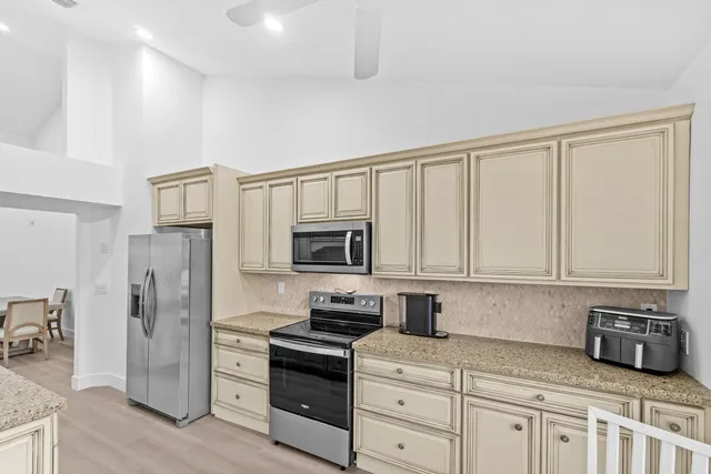 a kitchen with stainless steel appliances granite countertop a refrigerator stove and sink