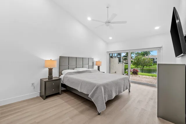 a bedroom with a bed and a flat tv screen on dresser