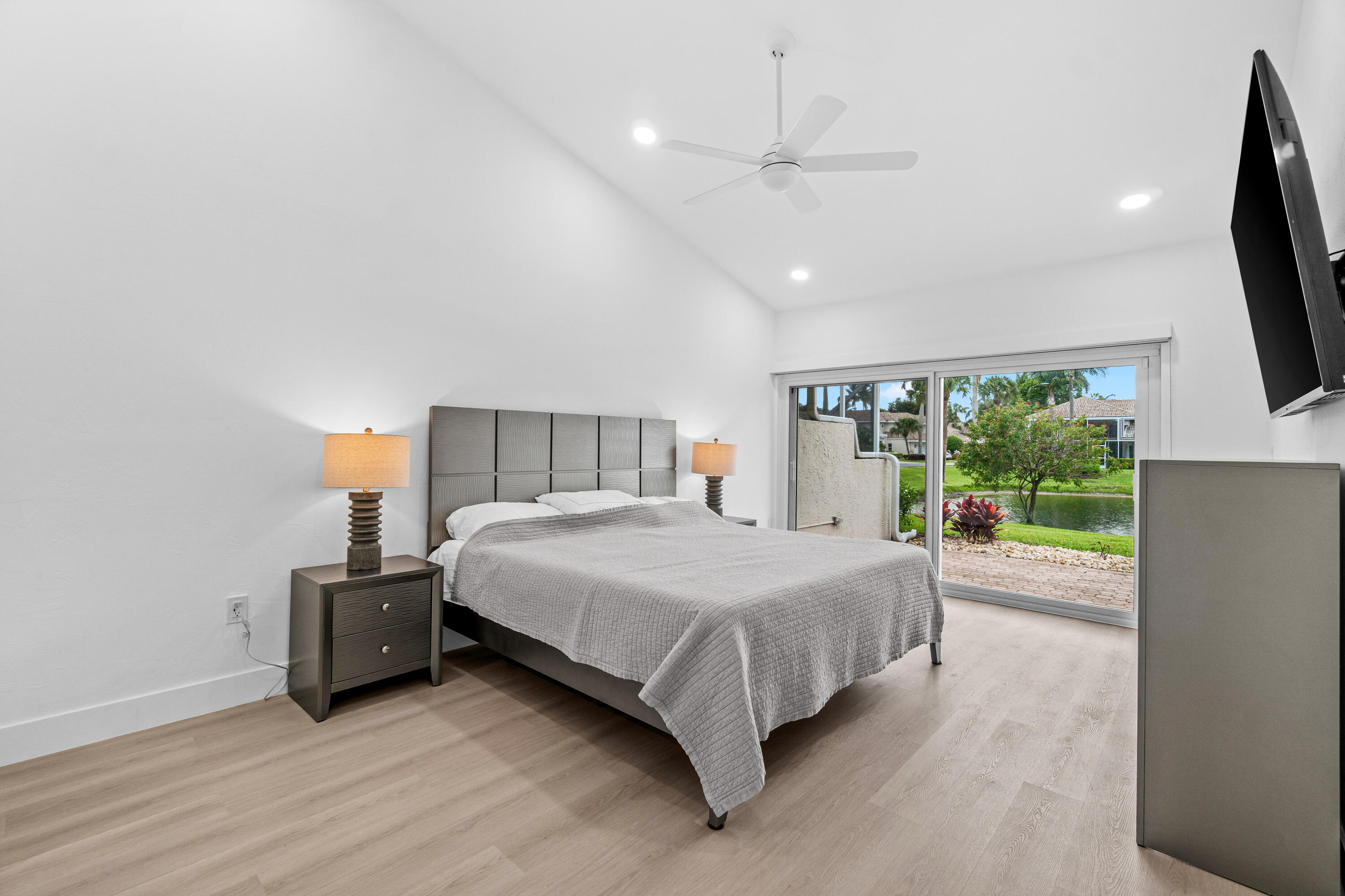 5097 Windsor Parke Drive Boca Raton, FL 33496 - Photo 17 of 30 a bedroom with a bed and a flat tv screen on dresser
