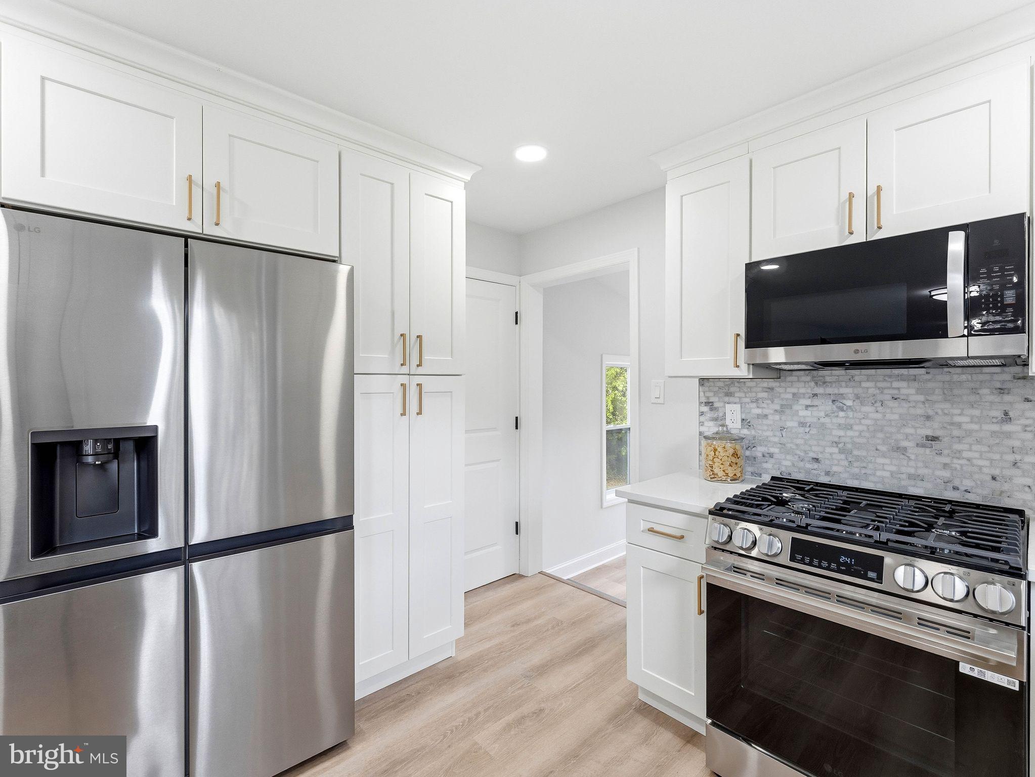 505 Greenwood Avenue Maple Shade, NJ 08052 - Photo 10 of 30 a view of a kitchen with a stove refrigerator microwave and cabinets