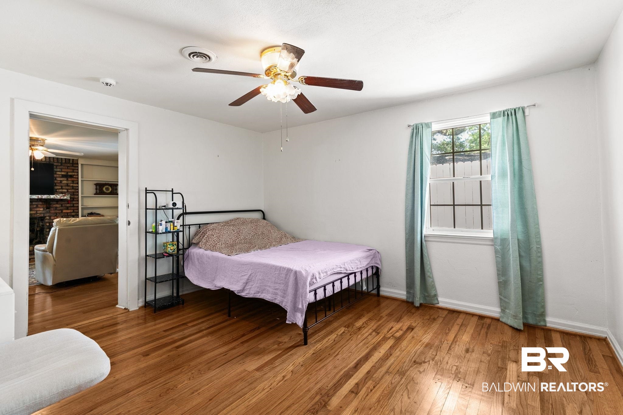 927 Cleveland Road Saraland, AL 36571 - Photo 26 of 80 Hardwood-finish flooring throughout, featuring a ceiling fan, window with natural light, and a doorway opening to an additional room