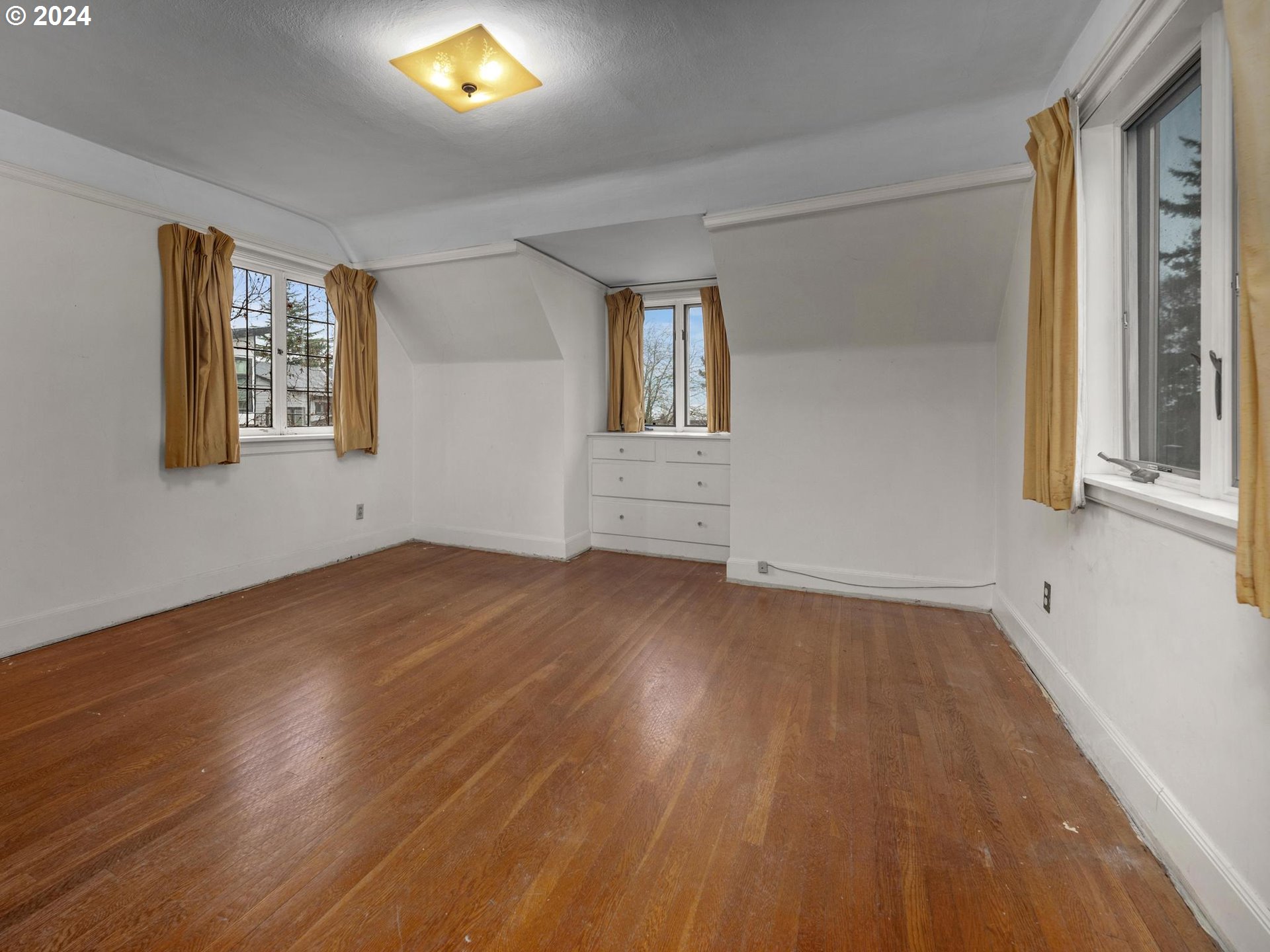 5523 Southwest Menefee Drive Portland, OR 97239 - Photo 14 of 22 a view of empty room with wooden floor and fan