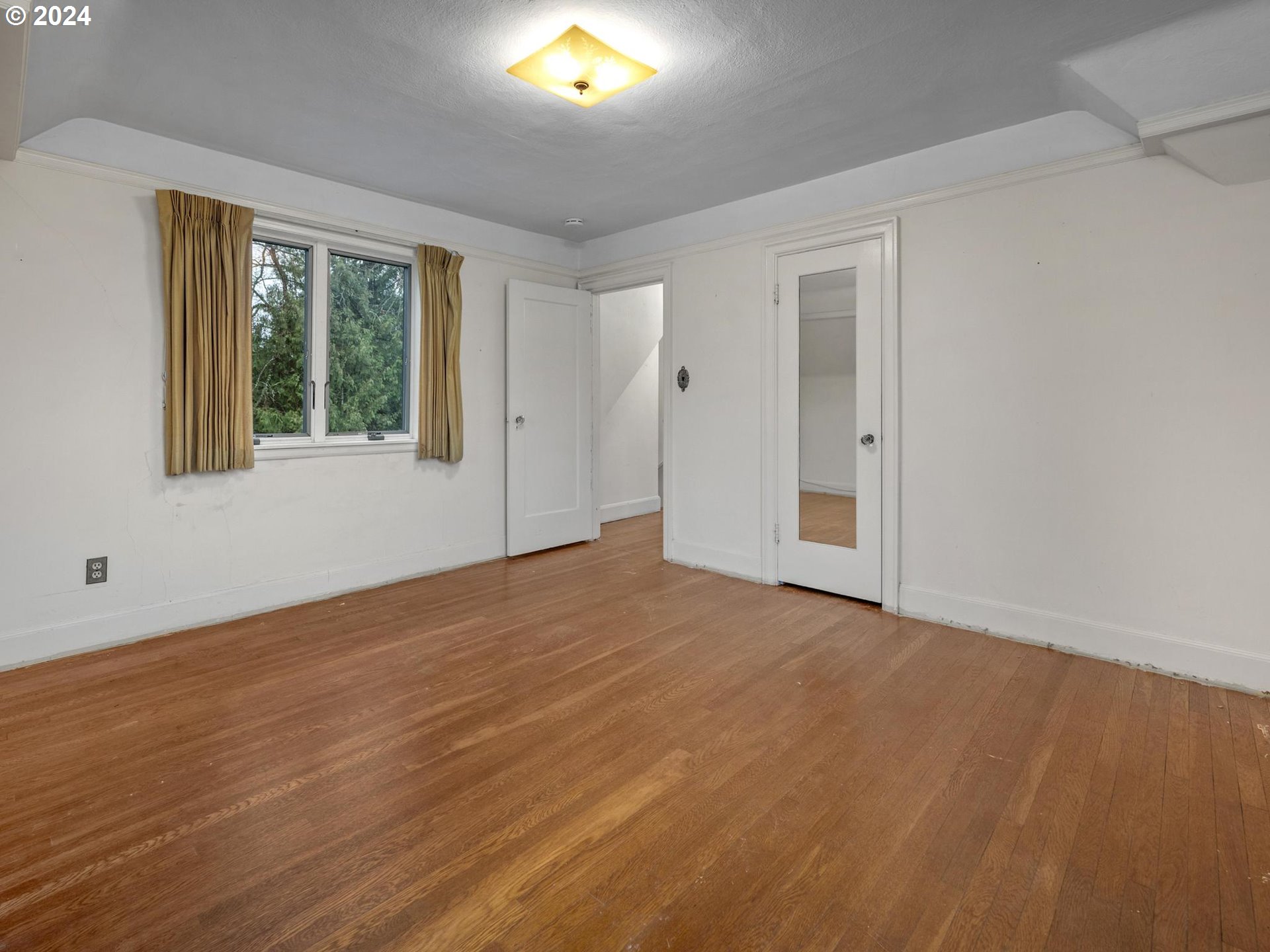 5523 Southwest Menefee Drive Portland, OR 97239 - Photo 15 of 22 a view of an empty room with wooden floor and a window