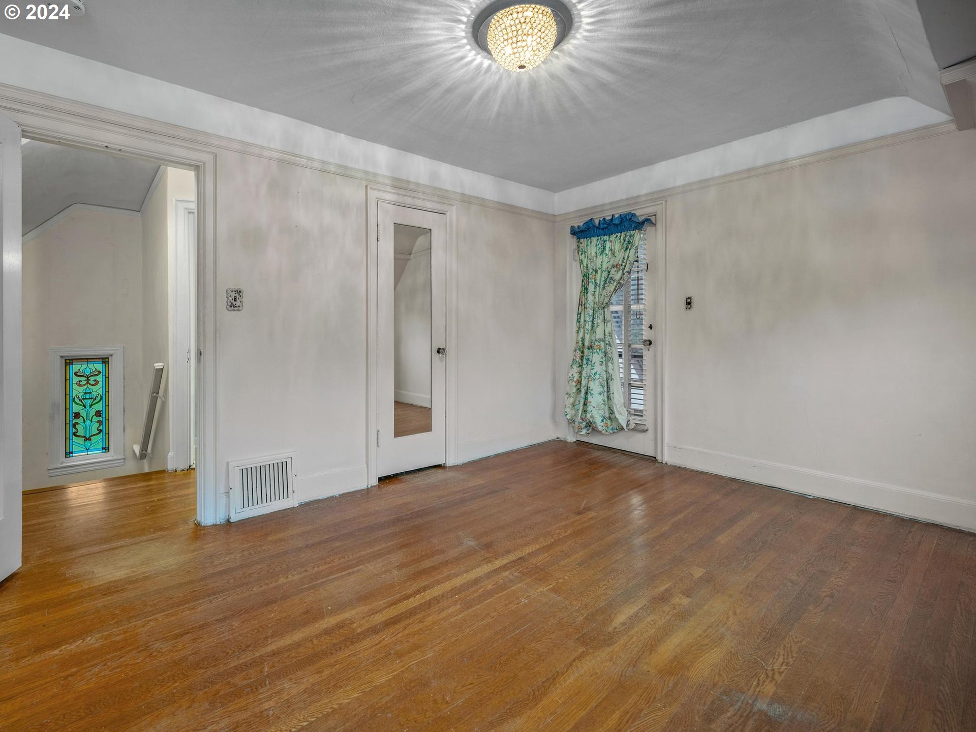 5523 Southwest Menefee Drive Portland, OR 97239 - Photo 18 of 22 a view of an empty room with wooden floor and a window