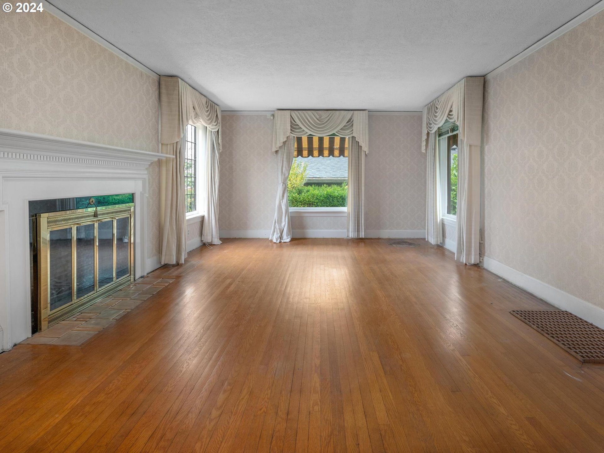 5523 Southwest Menefee Drive Portland, OR 97239 - Photo 4 of 22 a view of an empty room with wooden floor and a window