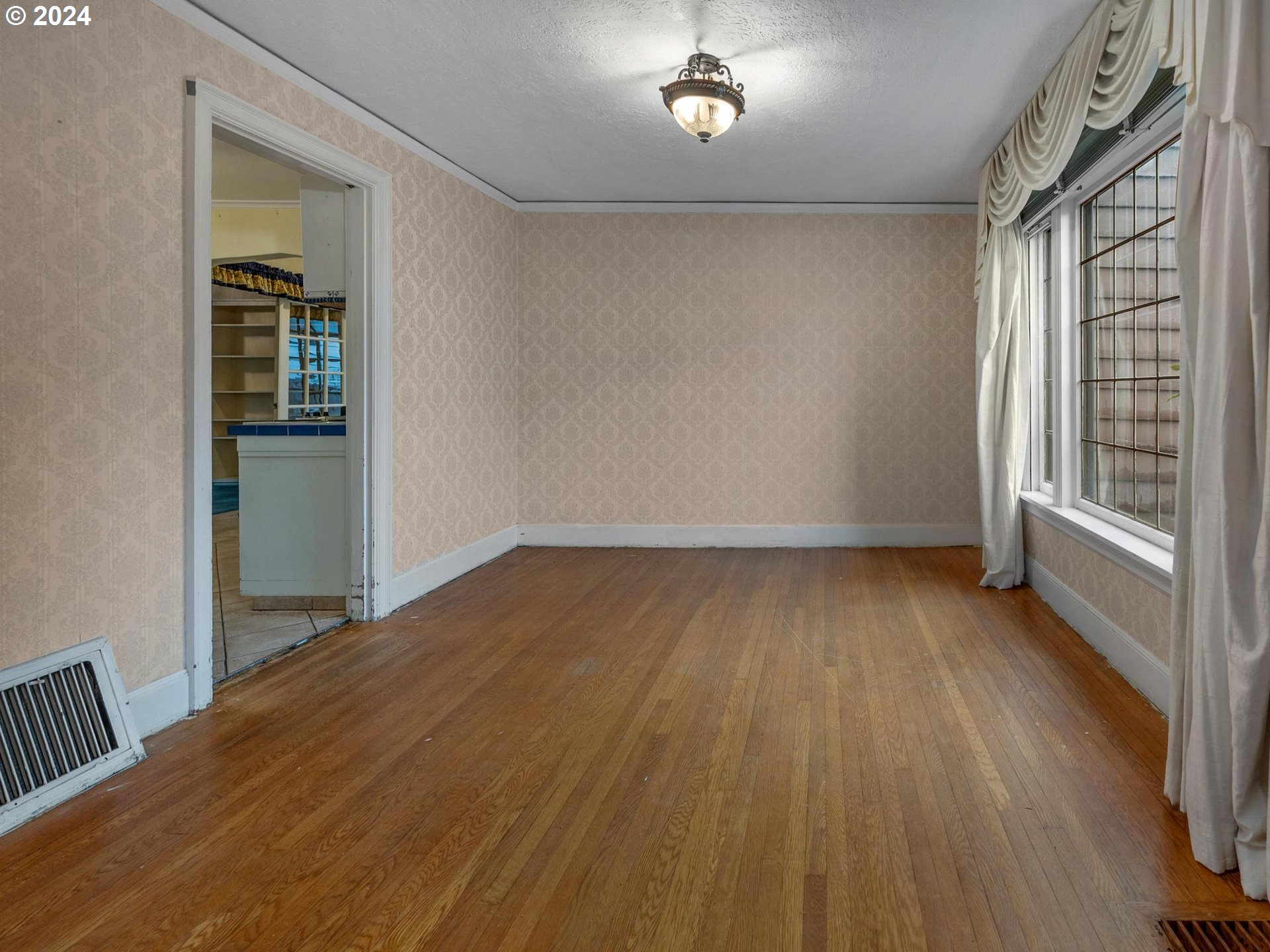 5523 Southwest Menefee Drive Portland, OR 97239 - Photo 5 of 22 wooden floor in an empty room with a window