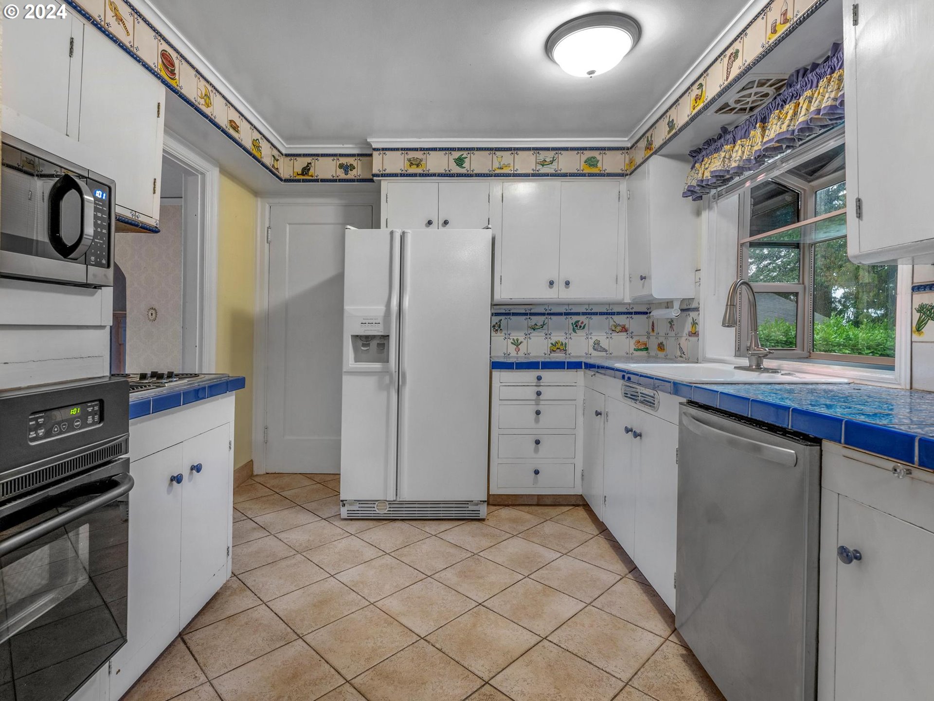5523 Southwest Menefee Drive Portland, OR 97239 - Photo 8 of 22 a kitchen with a refrigerator sink and cabinets