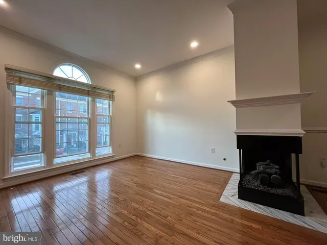 a view of a room with wooden floor fan and window