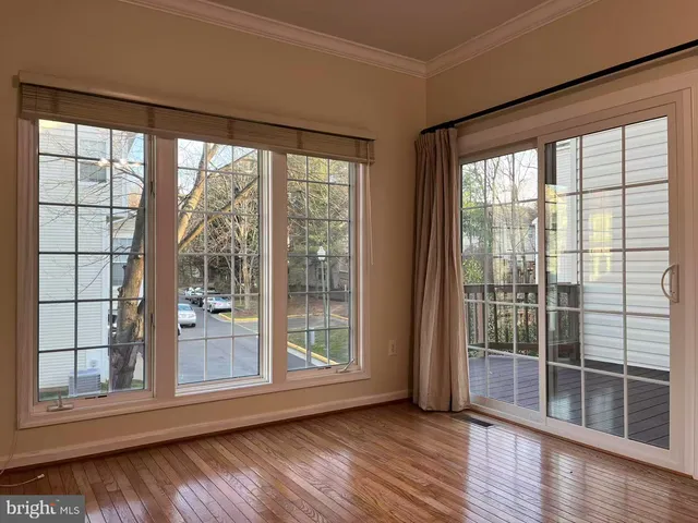 a view of a room with wooden floor and a table
