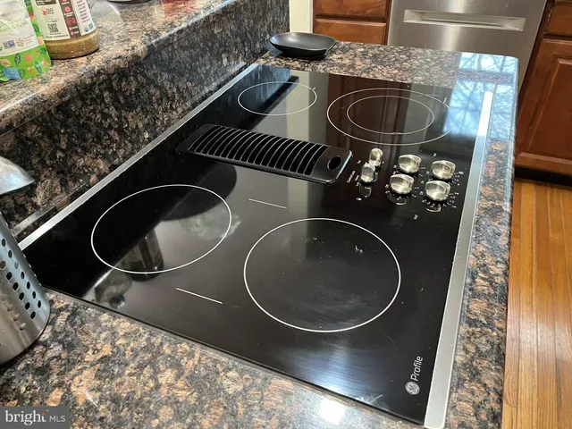 a kitchen with granite countertop stainless steel appliances and refrigerator