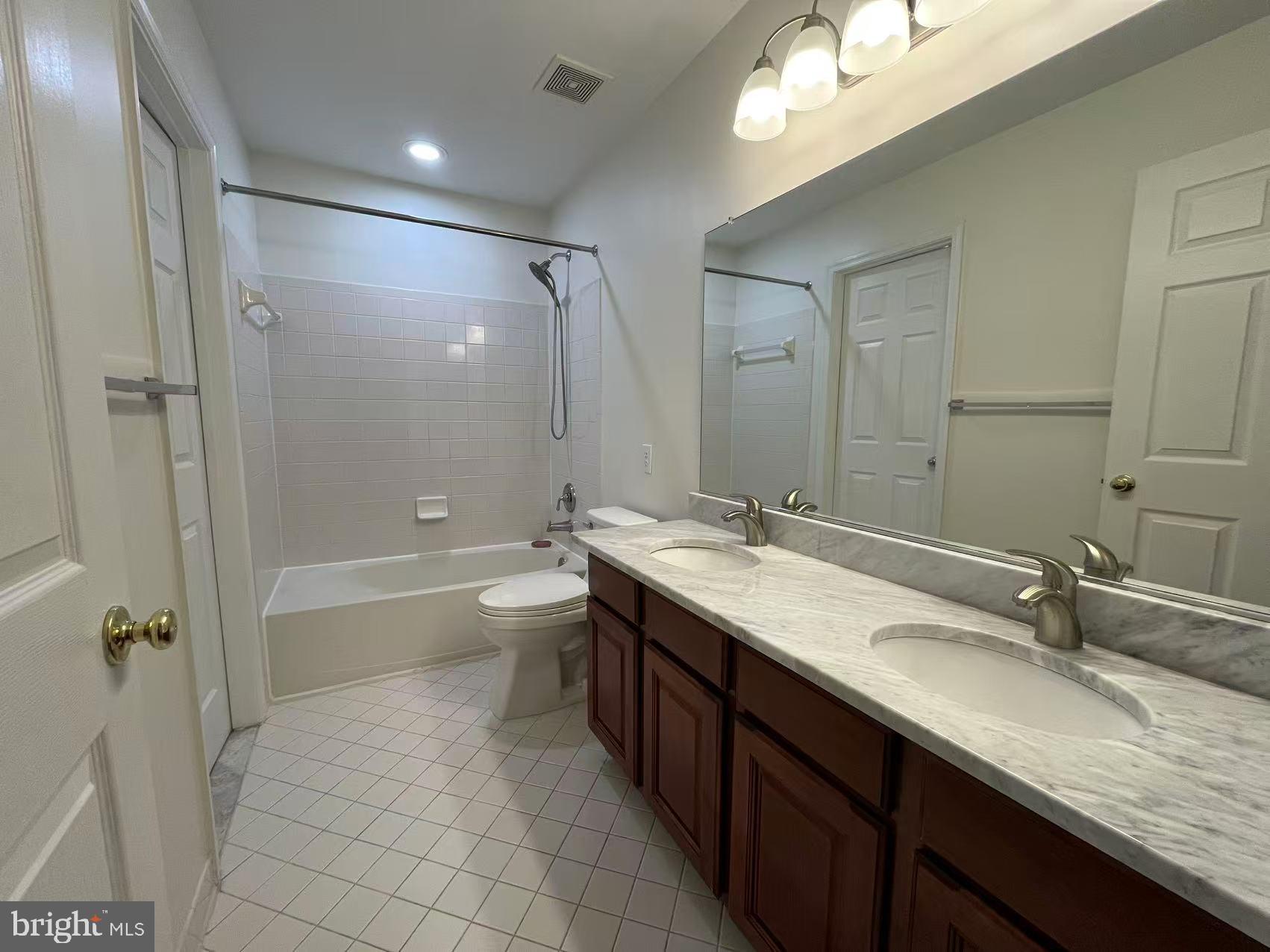 4102 Kentmere Square Fairfax, VA 22030 - Photo 36 of 55 a bathroom with a granite countertop sink a toilet a mirror a bathtub and shower