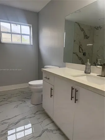 a bathroom with a sink a toilet and mirror