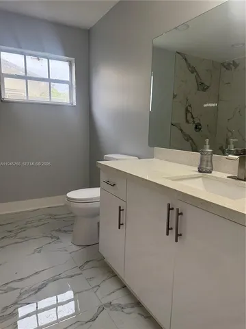 a bathroom with a sink a toilet and mirror