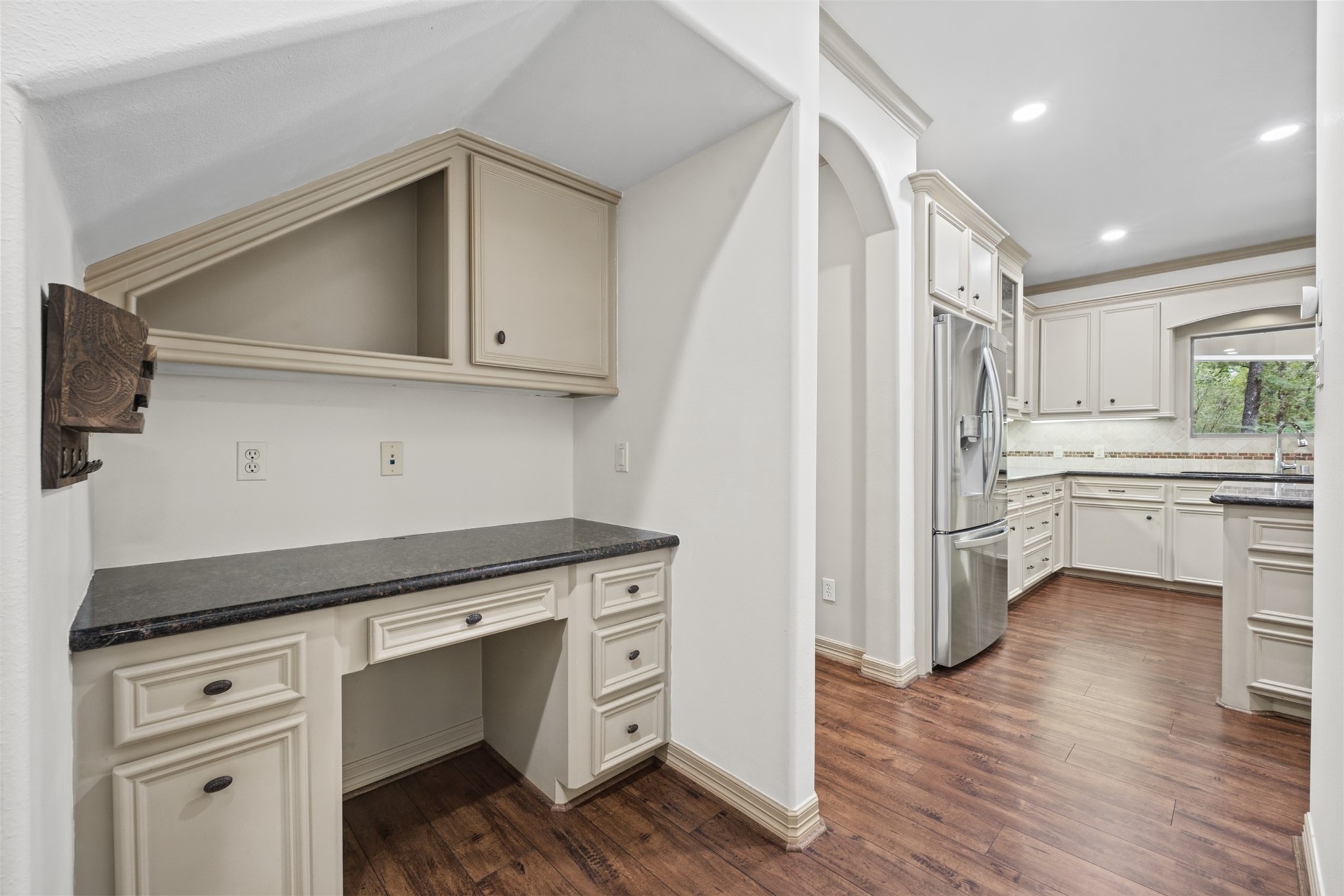 25119 Arcane Court Spring, TX 77389 - Photo 19 of 50 Organization Right Where You Need It! Ideally positioned between the Kitchen and Garage, this convenient chef’s desk creates a dedicated command center for keeping everyday life organized. Built-in cabinetry and workspace provide the perfect spot for mail, calendars, laptops, charging devices, meal planning, or managing the household—all within easy reach as you come and go.