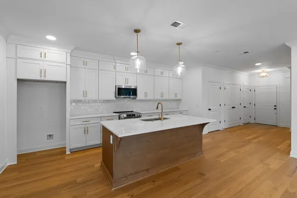 a kitchen with kitchen island a sink stainless steel appliances and cabinets