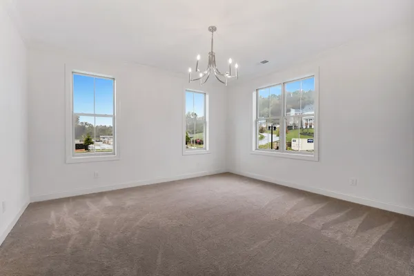 an empty room with windows and ceiling fan