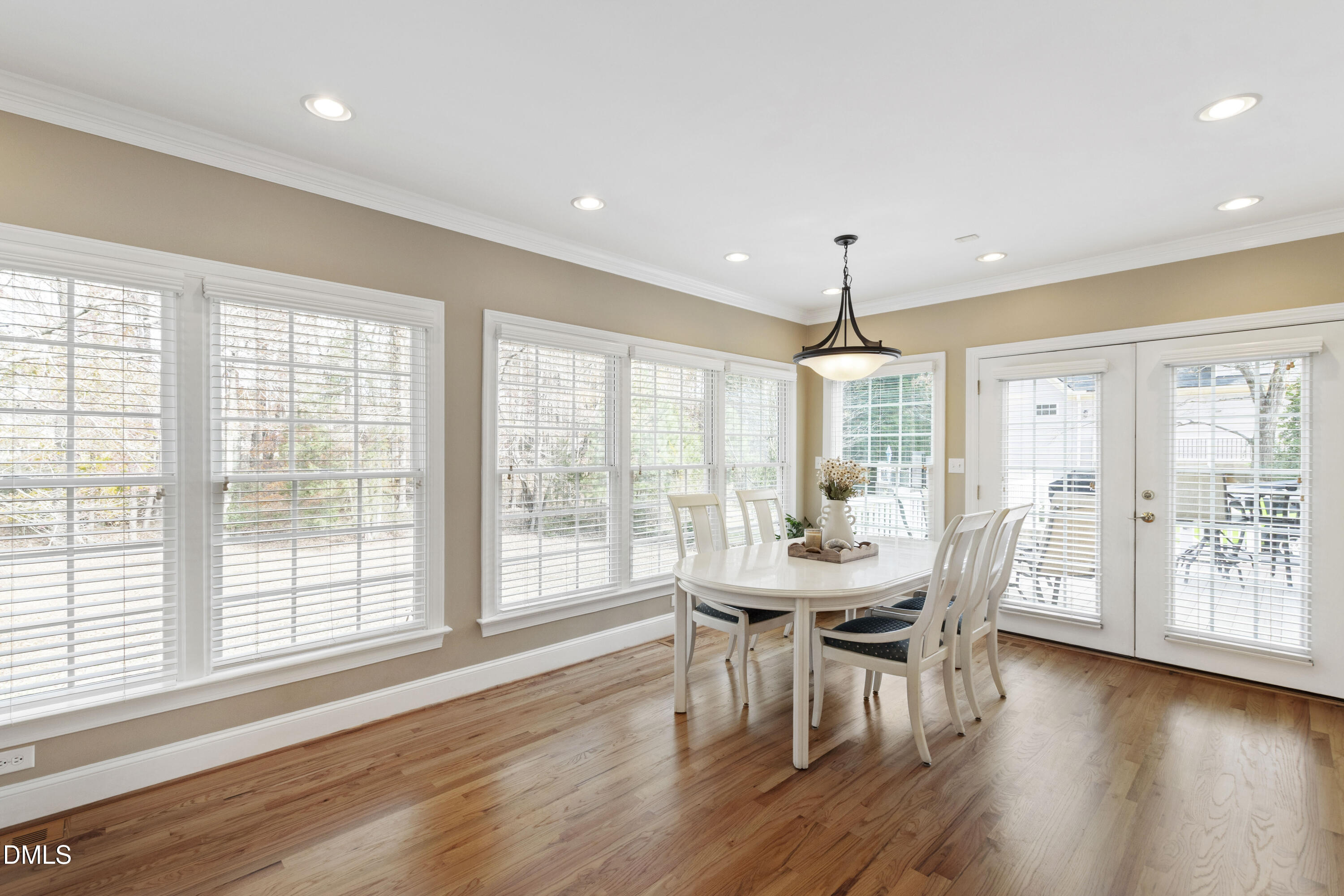 2405 Welsh Tavern Way Wake Forest, NC 27587 - Photo 14 of 58 a dining room with wooden floor a chandelier a glass table and chairs