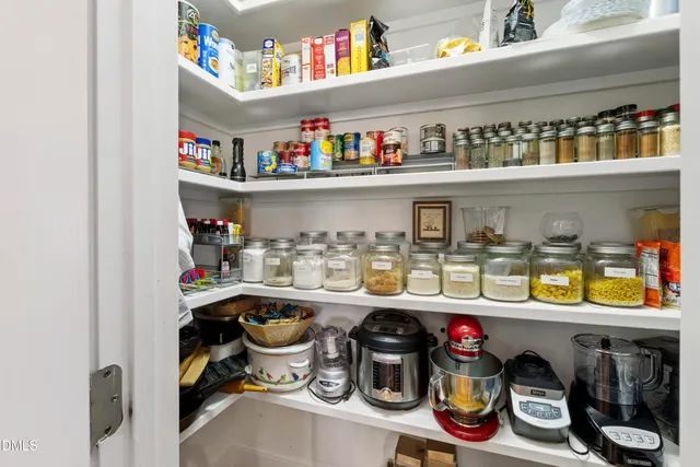 a kitchen with stainless steel appliances granite countertop a stove top oven a dining table and chairs with wooden floor