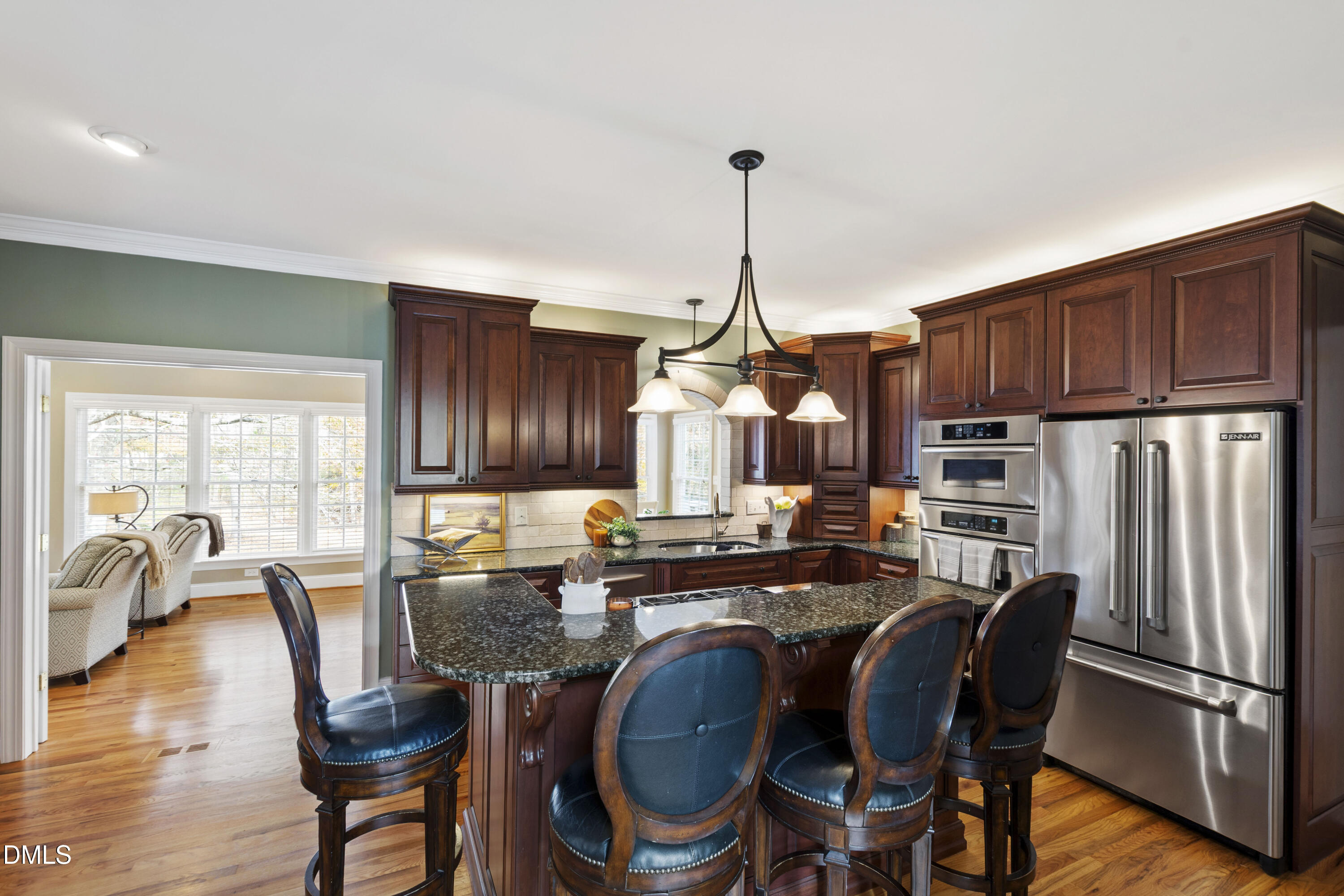 2405 Welsh Tavern Way Wake Forest, NC 27587 - Photo 19 of 58 a kitchen with granite countertop a refrigerator a stove a dining table and chairs with wooden floor