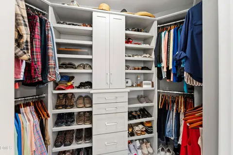 a bedroom with a bed and a flat tv screen on the dresser