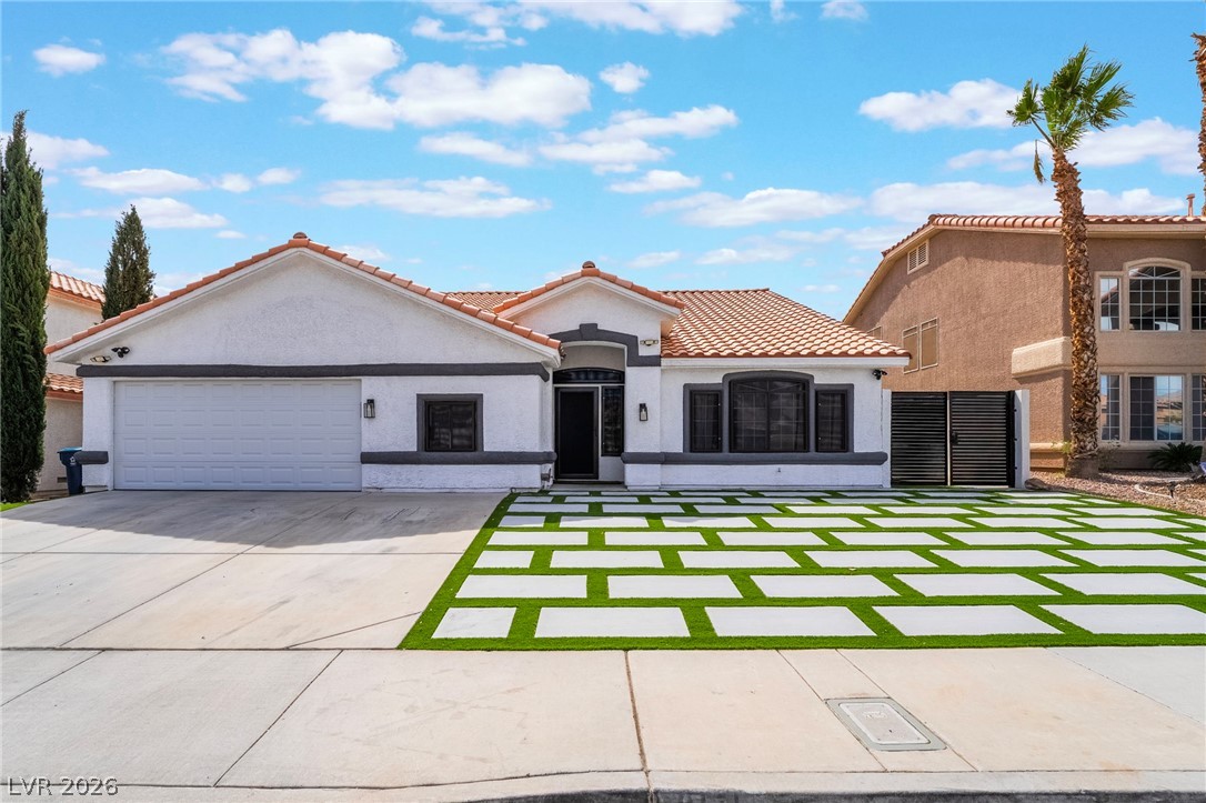 9171 West Viking Road Las Vegas, NV 89147 - Photo 5 of 43 A striking modern facade with clean lines and a dynamic checkerboard lawn.