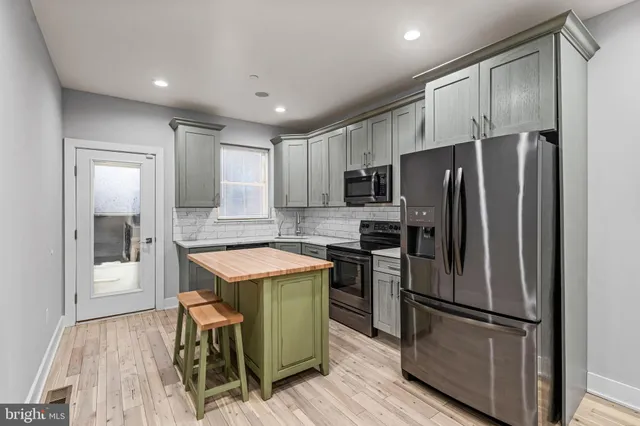 a kitchen with a refrigerator and a counter top space