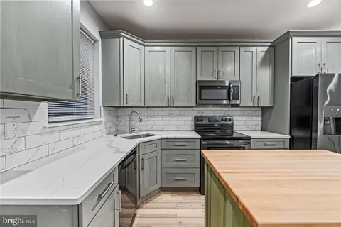 a kitchen with granite countertop a refrigerator and a sink