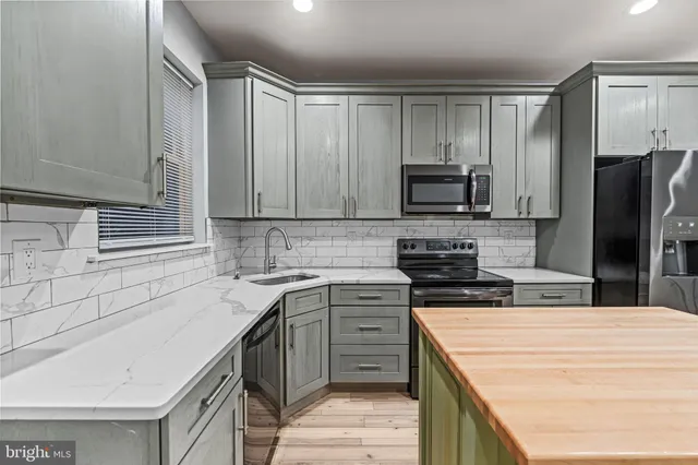 a kitchen with granite countertop a refrigerator and a sink