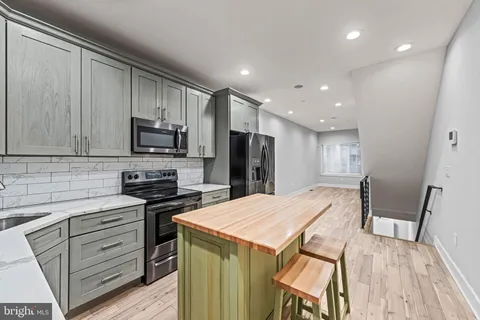 a kitchen with stainless steel appliances a stove sink microwave and refrigerator