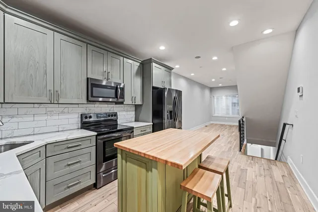 a kitchen with stainless steel appliances a stove sink microwave and refrigerator