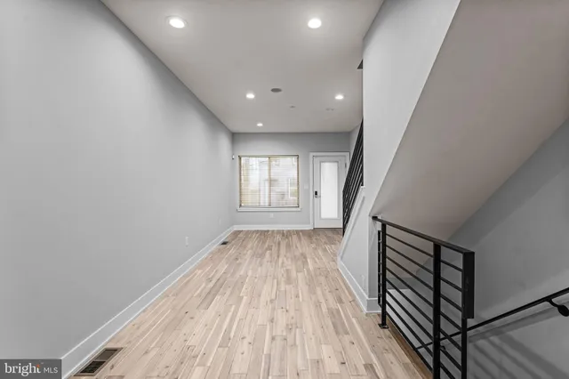 a view of a hallway with wooden floor and staircase