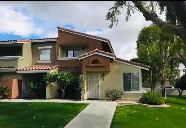 a front view of a house with a yard and potted plants