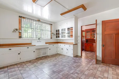a view of a kitchen with granite countertop a sink and a stove top oven