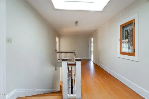 a view of a hallway with wooden floor and staircase