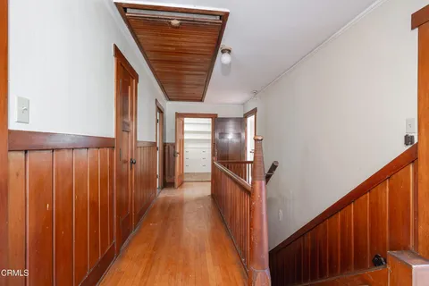 a view of a hallway with wooden floor and staircase