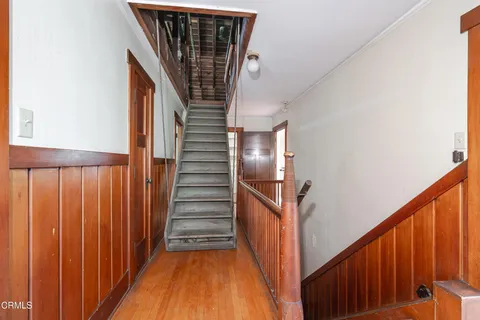 a view of an empty room with wooden stairs