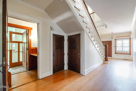 an empty room with wooden floor fireplace and windows