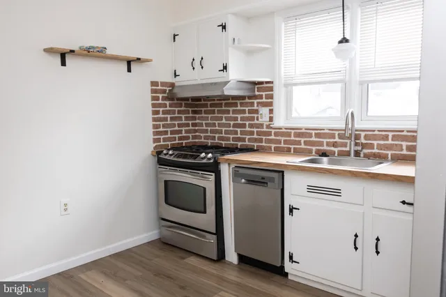 a view of a refrigerator in kitchen and an empty room