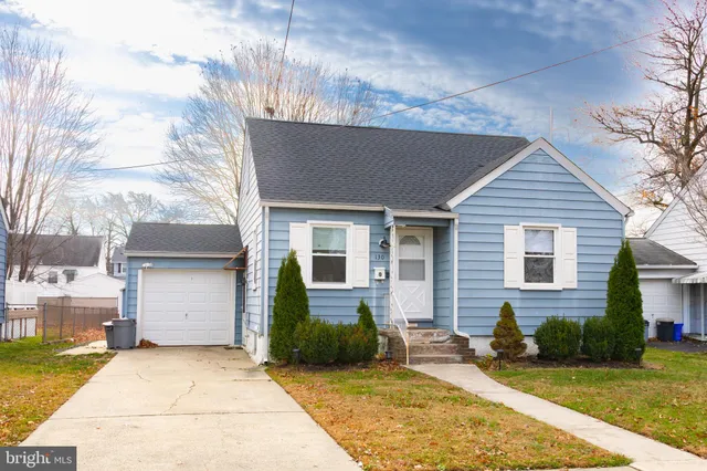 a view of an empty room with wooden floor and a fireplace