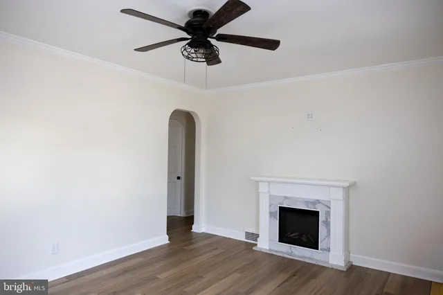 an empty room with a window and a ceiling fan