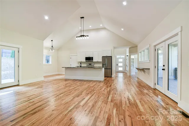 a view of kitchen with cabinets stainless steel appliances and wooden floor
