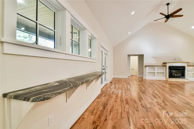 a view of a livingroom with wooden floor and a ceiling fan