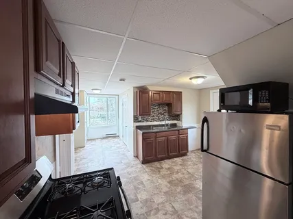 a kitchen with stainless steel appliances granite countertop a refrigerator and a stove